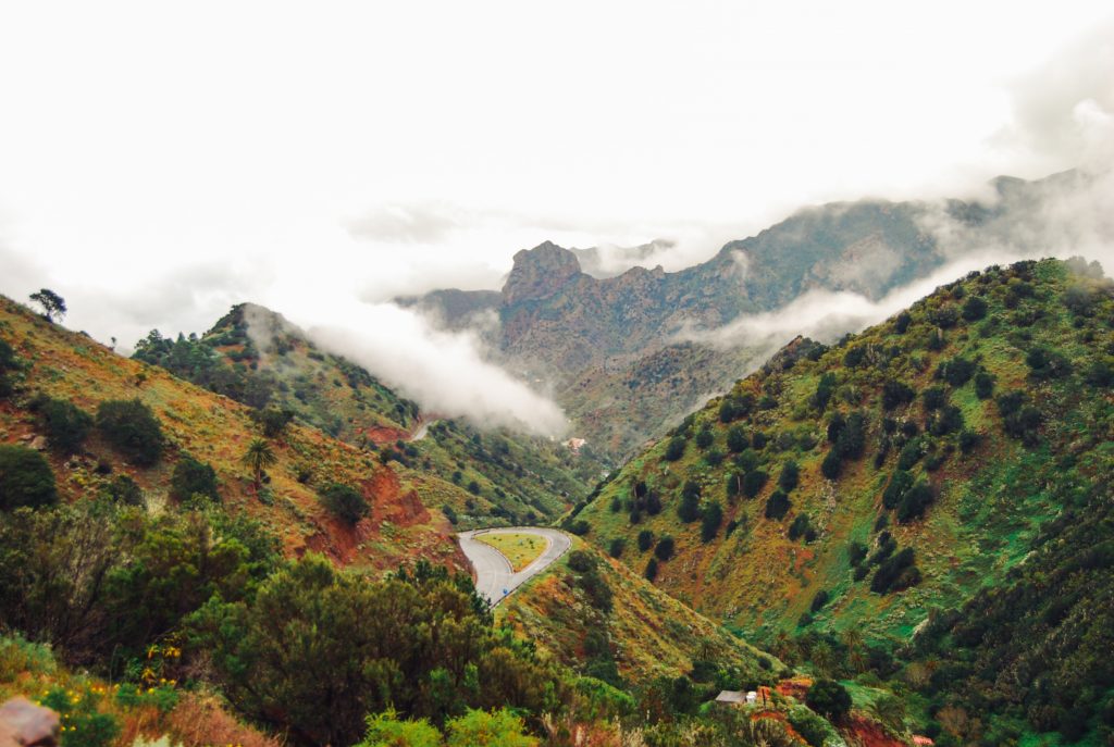 High mountains covered in greenery and clouds.